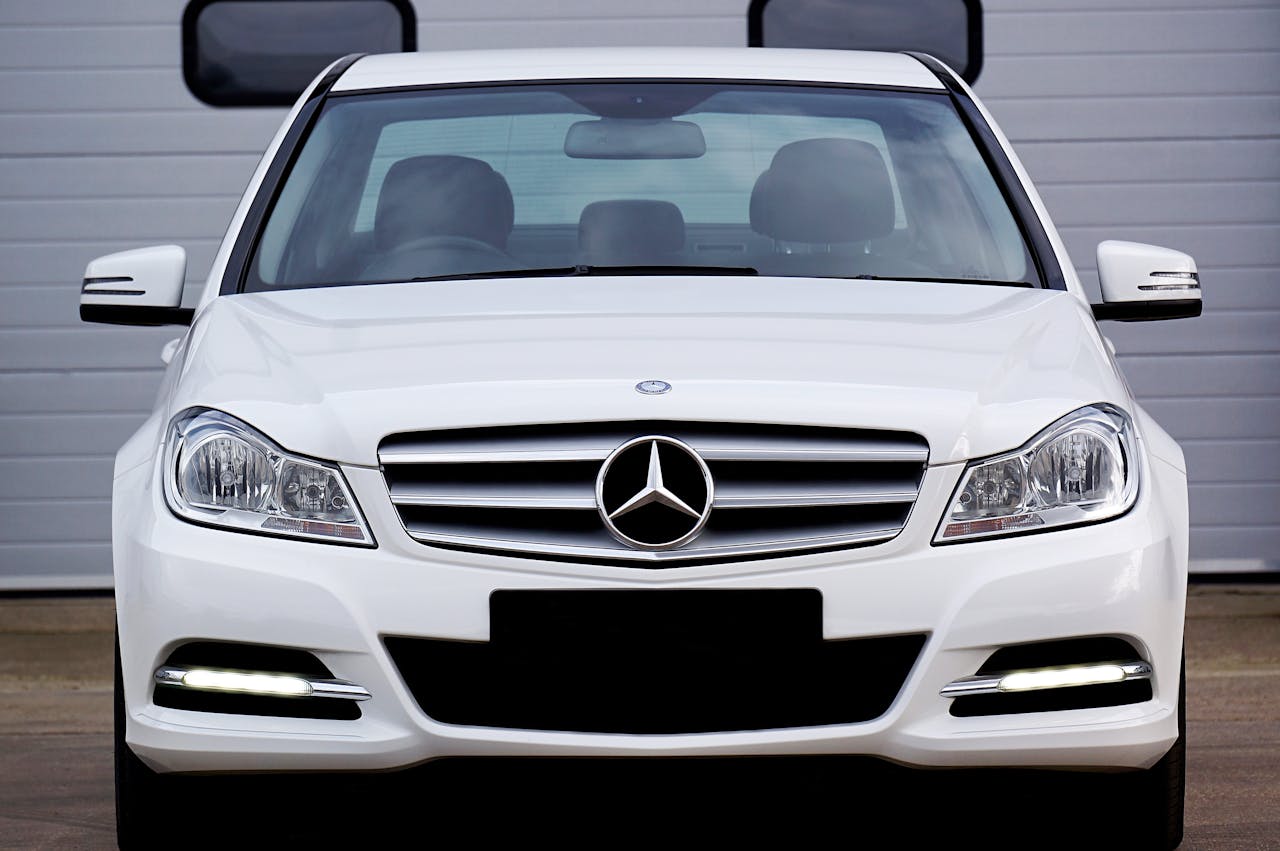 A shiny white Mercedes Benz sedan with chrome details photographed outdoors in Scotland.